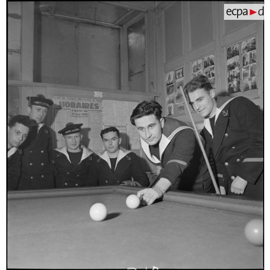 Jean Kerlevéo, prêtre marin affecté à bord du croiseur Georges Leygues, dispute une partie de billard français.