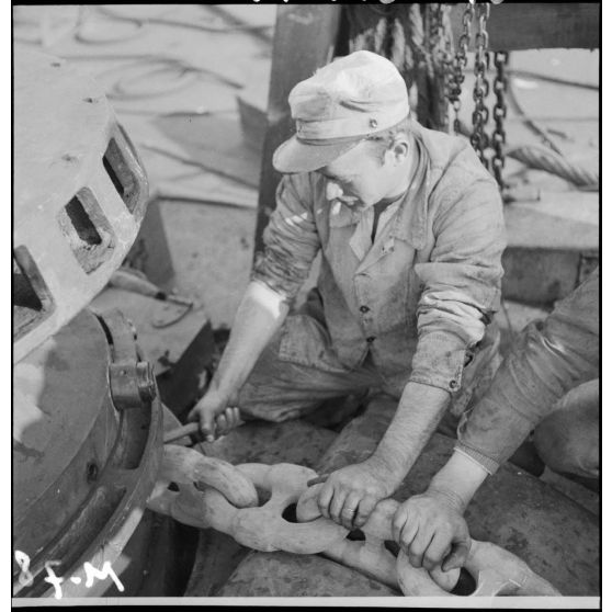 Mise en place de l'une des chaînes d'ancrage sur le chantier de construction du croiseur Richelieu à l'arsenal de Brest.