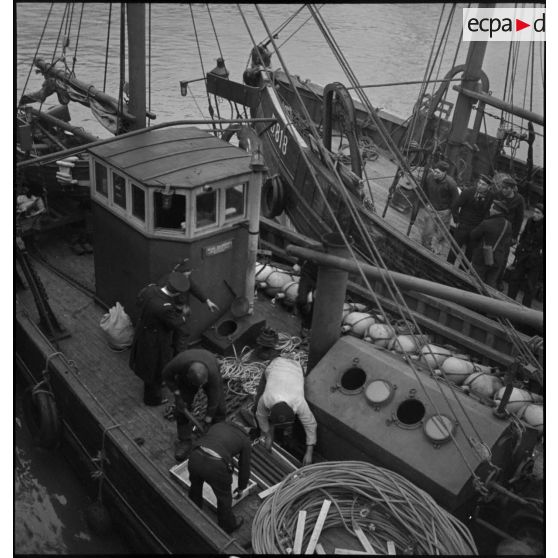 Préparation de grenades anti-sous-marines à bord d'un chalutier de la Marine nationale.