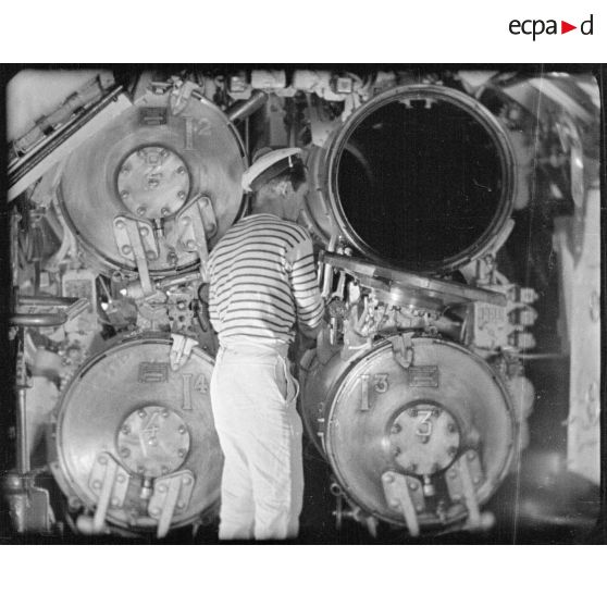 Gros plan sur les tubes lance-torpilles dans une salle des torpilles à bord d'un sous-marin.