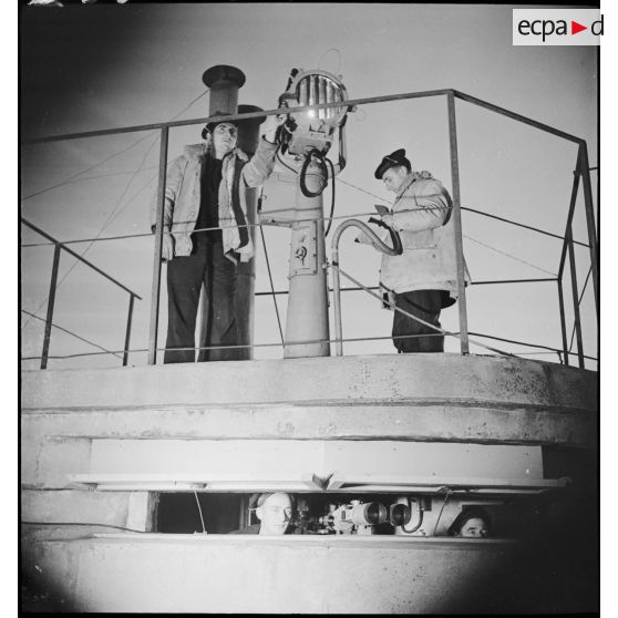 Deux marins sont au poste de veille à la lanterne Scott, au-dessus du blockhaus, à bord du torpilleur Branlebas.