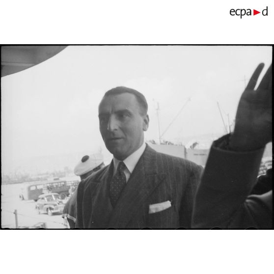 Louis Jacquinot, commissaire à la Marine nationale, monte à bord de l'escorteur l'Algérien à quai dans le port d'Alger.