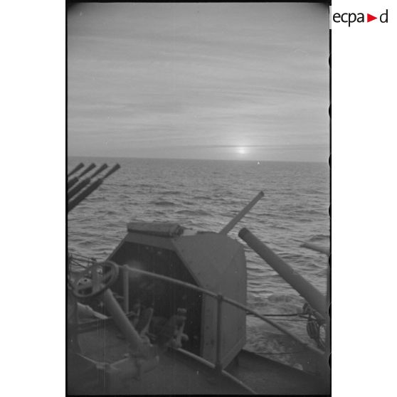 Coucher de soleil depuis un poste d'artillerie sous masque d'un navire de la Marine nationale.