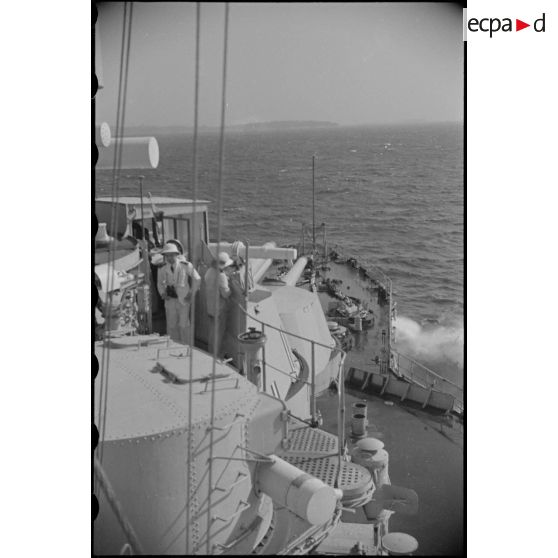 Plage avant d'un croiseur naviguant au large d'une côte.