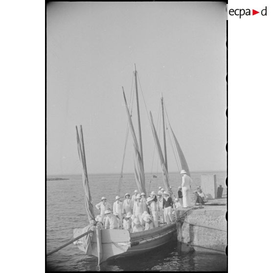Equipage d'un croiseur à bord d'une baleinière à quai.