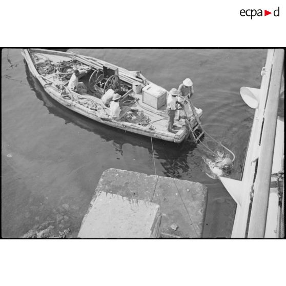 Sortie de l'eau d'un scaphandrier du croiseur lourd Duquesne, probablement à l'issue d'une mission d'inspection de la coque du navire.