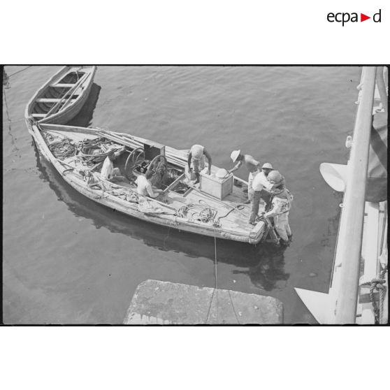 Sortie de l'eau d'un scaphandrier du croiseur lourd Duquesne, probablement à l'issue d'une mission d'inspection de la coque du navire.