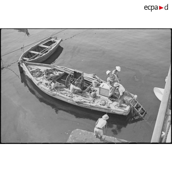 Sortie de l'eau d'un scaphandrier du croiseur lourd Duquesne, probablement à l'issue d'une mission d'inspection de la coque du navire.