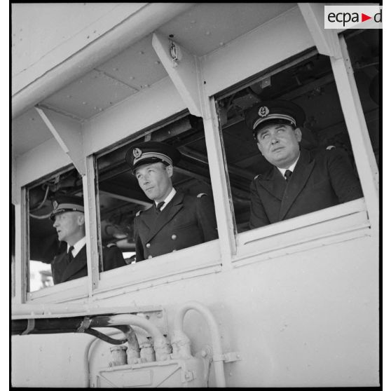 Le capitaine de corvette Gaston Bataille, commandant le torpilleur Simoun, est à la passerelle du bâtiment, entouré de deux officiers de son état-major.