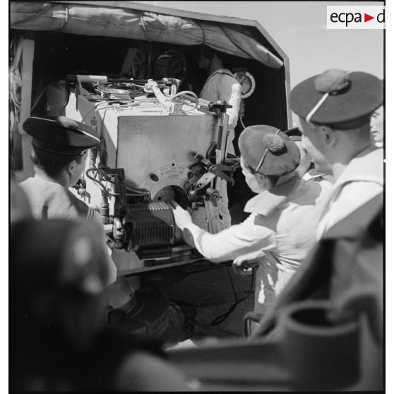 Après avoir chargé un obus dans un canon à bord du  torpilleur Simoun, des canonniers ferment la culasse.