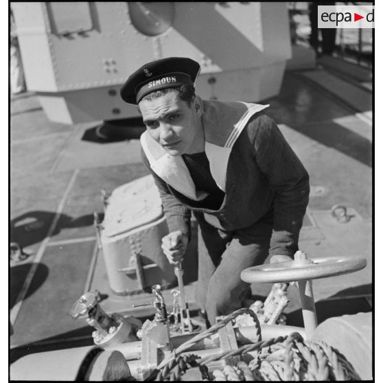 Marin actionnant un treuil à bord du torpilleur Simoun.