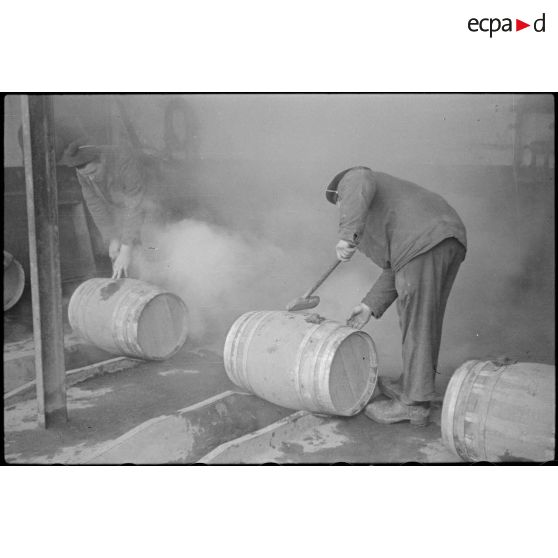 Des marins fabriquent des tonneaux à la section des liquides de l'arsenal de Brest.
