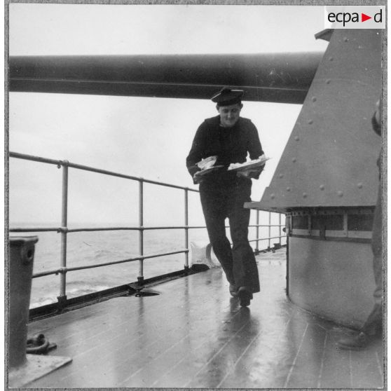 Un matelot, maître d'hôtel à bord du cuirassé Dunkerque, apporte un repas au vice-amiral Marcel Gensoul à bord du cuirassé Dunkerque.