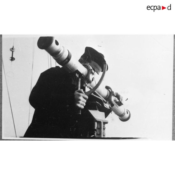 Un matelot télémétreur utilise un télémètre pour déterminer la distance d'un objectif à bord du contre-torpilleur Le Malin.