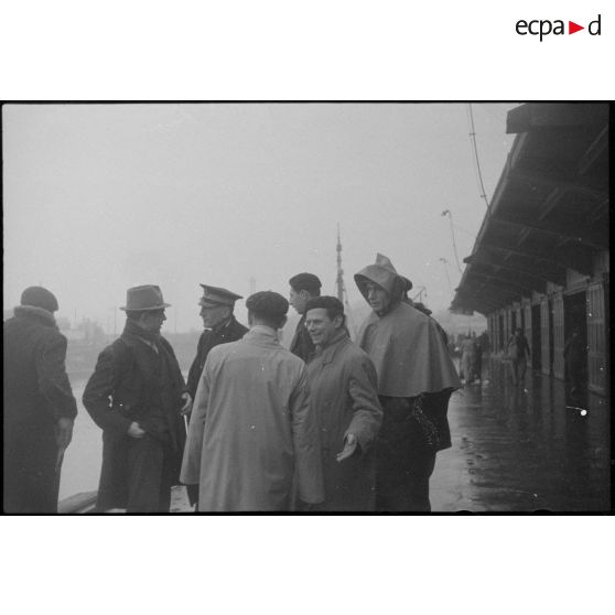 Journalistes rassemblés sur un quai dans le port de Lorient.