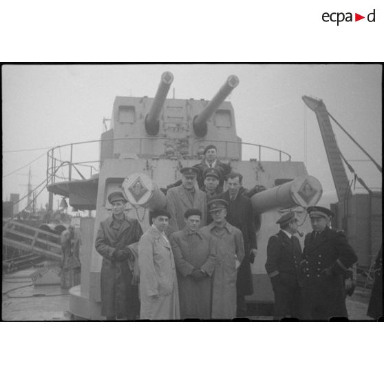 Officiers français, britanniques et journalistes posant devant des tourelles doubles de canons de 138 mm du contre-torpilleur Mogador.