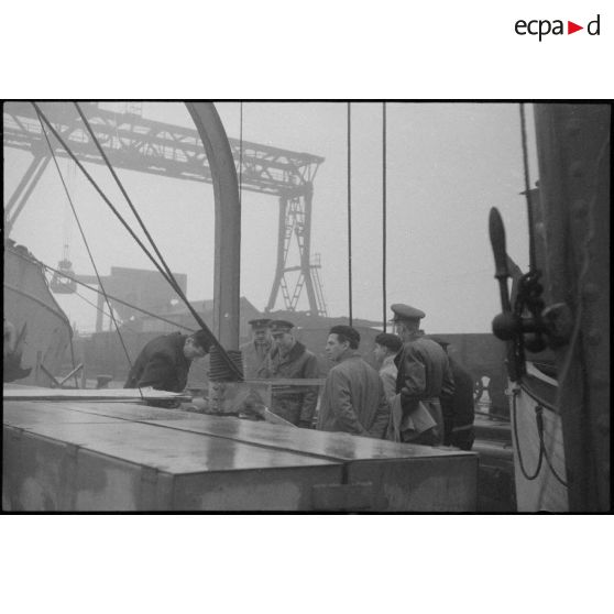 Officiers français, britanniques et journalistes sur le pont d'un navire.