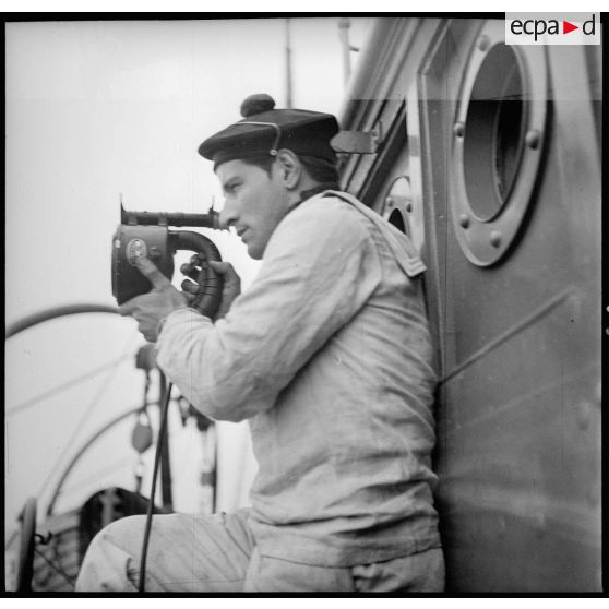 Utilisation d'un projecteur de signalisation par un marin.