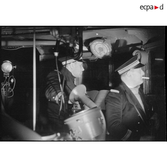 Capitaine de corvette et lieutenant de vaisseau de quart de nuit sur la passerelle d'un torpilleur.