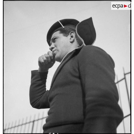 Un matelot rend les honneurs au sifflet à bord du croiseur (ou cuirassé) Dunkerque.