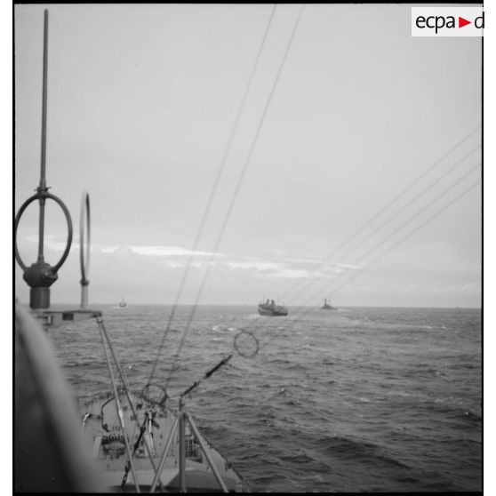 Convoi de navires transports de troupes naviguant vers la France, escortés par des bâtiments de la Marine nationale.
