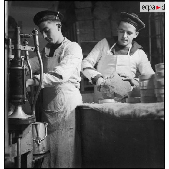 Portraits de matelots cuisiniers préparant des rations de pain et de vin pour l'équipage du croiseur (ou cuirassé) Dunkerque.