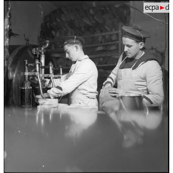Portraits de matelots cuisiniers préparant des rations de pain et de vin pour l'équipage du croiseur (ou ciurassé) Dunkerque.