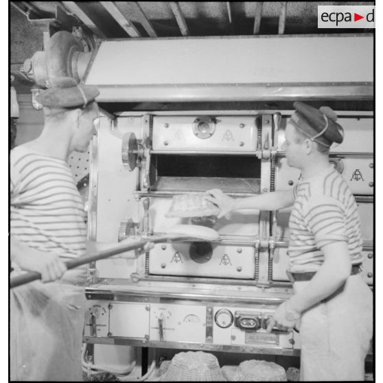 Les boulangers du croiseur (ou cuirassé) Dunkerque sortent du pain du four.