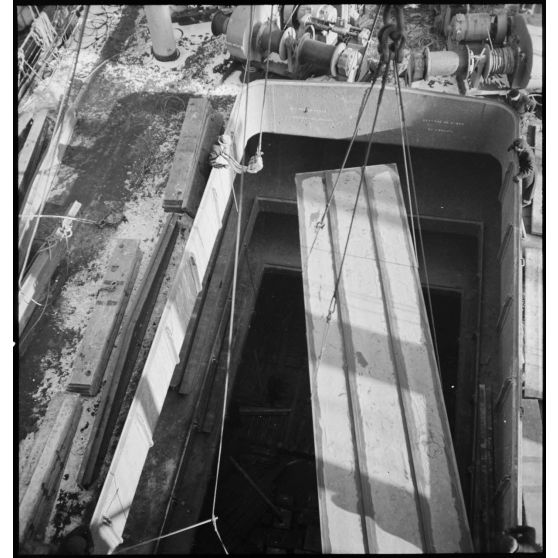 Dans le port de New-York pris par les glaces, une caisse qui contient un avion destiné aux Alliés est descendue dans la cale d'un cargo.