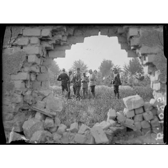 Cimetière de La Neuvillette, près de Reims. Général de Mondésir et ses officiers d’Etat-major en conversation, vue prise par un trou d’obus. [légende d’origine]