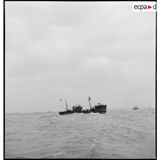 Un chalutier armé par la Marine nationale sort d'un port pour une mission de patrouille.