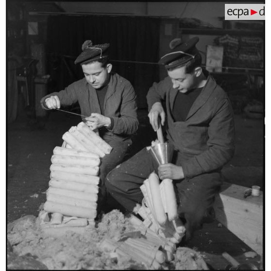 Atelier central de la flotte : des marins confectionnent  des ceintures de sauvetage.