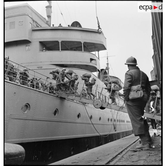 Des chasseurs alpins du 13e bataillon de chasseurs alpins (BCA) embarquent par la coupée à bord du croiseur auxiliaire le Ville d'Oran à destination de l'Ecosse puis de la Norvège.