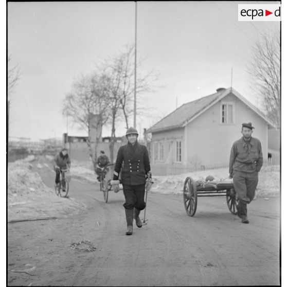 Corvée de ravitaillement en vivres de marins d'un des navires ancrés dans le port de Namsos.