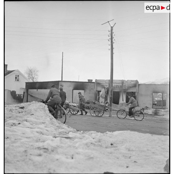 Corvée de ravitaillement en vivres de marins d'un des navires ancrés dans le port de Namsos.