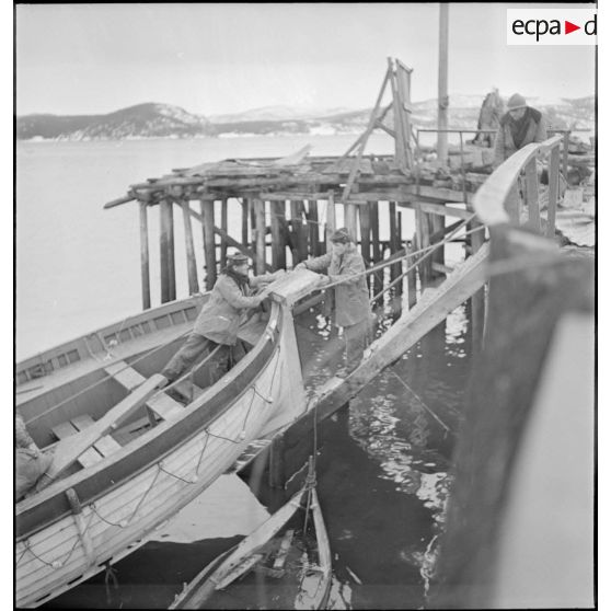 Récupération de matériels divers par des marins français dans le port de Namsos en ruine.