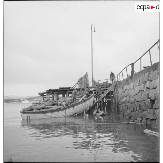 Récupération de matériels divers par des marins français dans le port de Namsos en ruine.