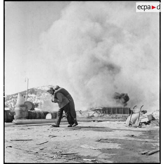 Evacuation d'un blessé dans Namsos incendié.