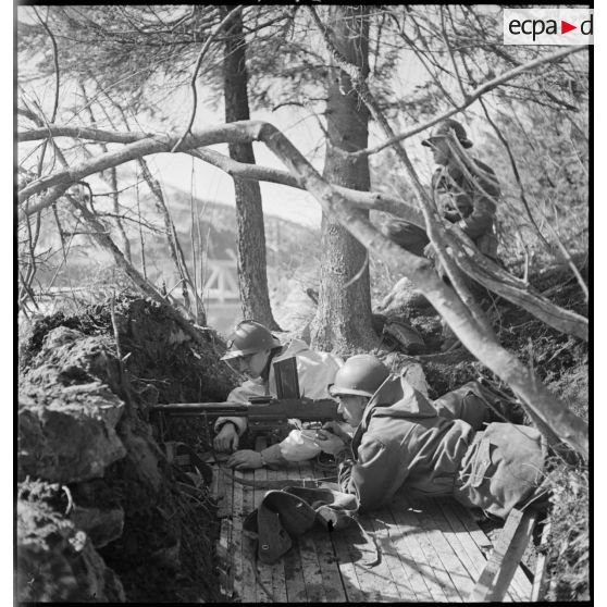Un chasseur alpin de la 1ère DLCh (Division légère de chasseurs), tireur au FM 24-29, est posté en position de tir dans un trou de combat.