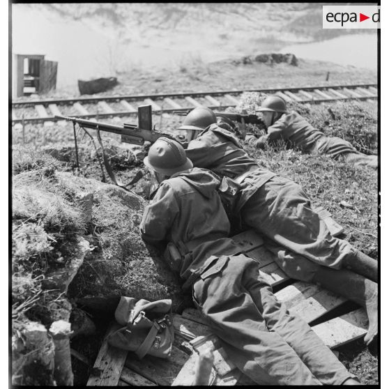 Des chasseurs alpins de la 1ère DLCh (Division légère de chasseurs), tireurs au FM 24-29 et au MAS 36, sont postés en surplomb d'une voie ferrée.