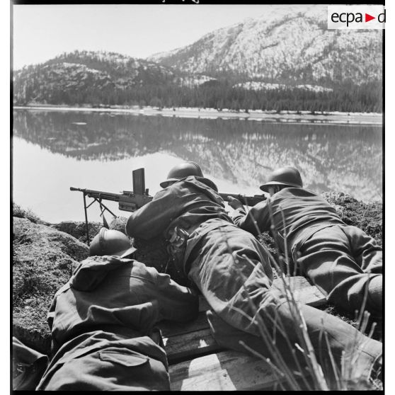 Des chasseurs alpins de la 1ère DLCh (Division légère de chasseurs), tireurs au FM 24-29 et au MAS 36, sont postés en surplomb d'une voie ferrée longeant un fjord.
