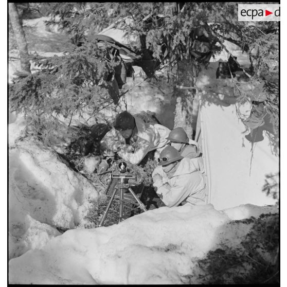 Des chasseurs alpins de la 1ère DLCh (Division légère de chasseurs), servants d'un mortier Stokes-Brandt de 81 mm, sont postés dans un trou de combat.