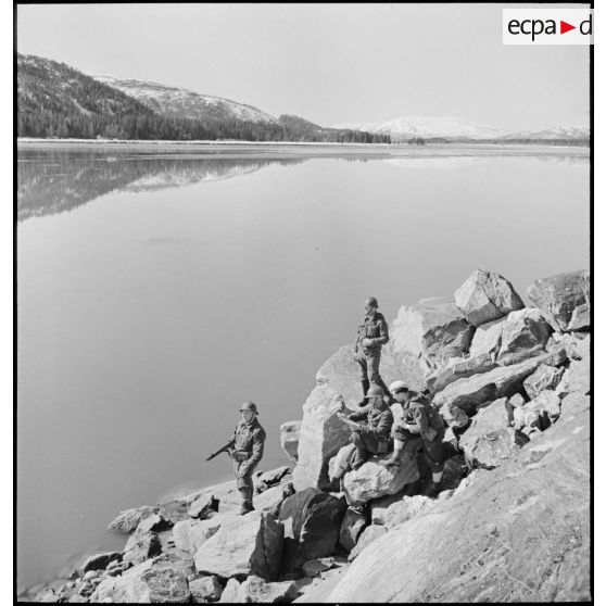 Des chasseurs alpins de la 1ère DLCh (Division légère de chasseurs) observent les hauteurs entourant un fjord.