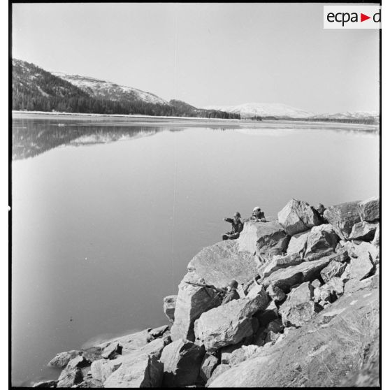 Des chasseurs alpins de la 1ère DLCh (Division légère de chasseurs) observent les hauteurs entourant un fjord.