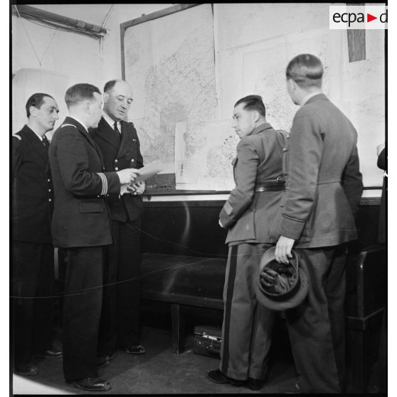 Point de situation devant une carte murale au poste de commandement de l'amiral Abrial.