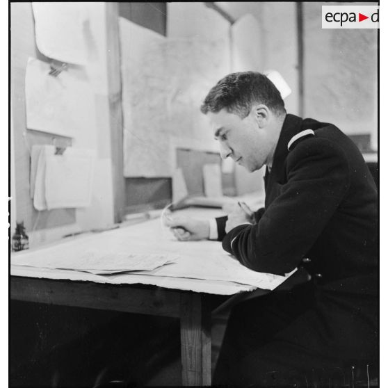 Un officier d'état-major de la marine nationale est penché sur des documents au poste de commandement de l'amiral Abrial à Dunkerque.