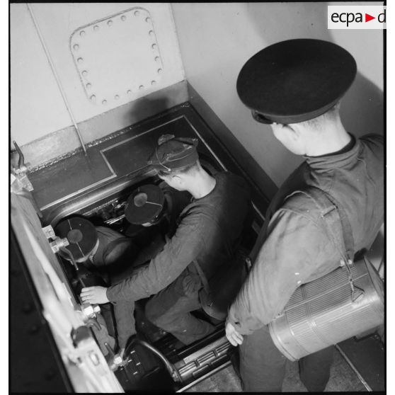 Alerte à bord du cuirassé Dunkerque : les marins chauffeurs et mécaniciens rejoignent leurs postes de combat dans le compartiment des machines.