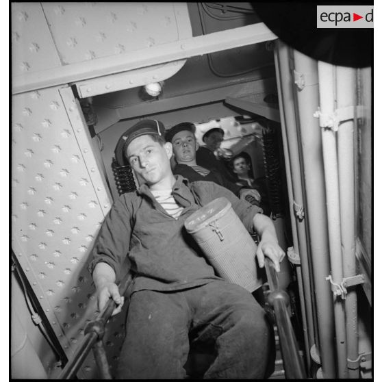 Alerte à bord du cuirassé Dunkerque : les marins chauffeurs et mécaniciens rejoignent leurs postes de combat dans le compartiment des machines.