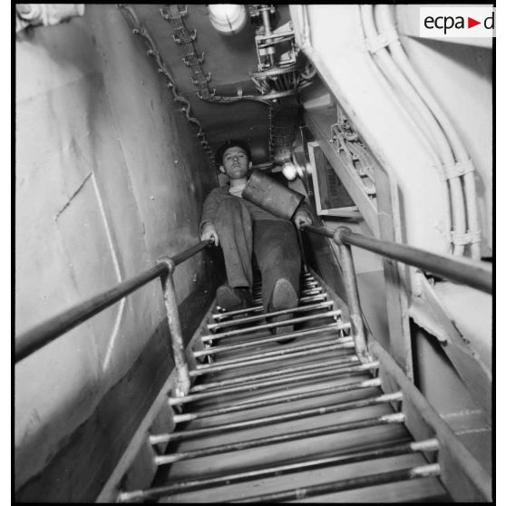 Alerte à bord du cuirassé Dunkerque : les marins chauffeurs et mécaniciens rejoignent leurs postes de combat dans le compartiment des machines.