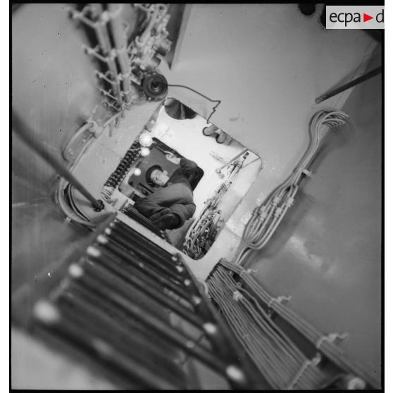 Alerte à bord du cuirassé Dunkerque : les marins chauffeurs et mécaniciens rejoignent leurs postes de combat dans le compartiment des machines.